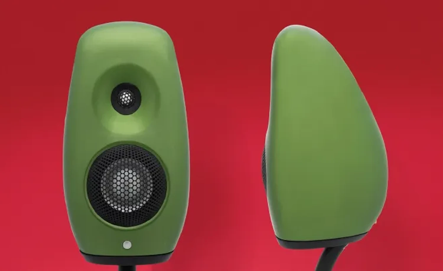 Deux enceintes Vivid Audio Kaya S12 vertes sur fond rouge, l'une tournée vers l'avant avec son haut-parleur d'aigus (tweeter) et son haut parleur de médium-grave, l'autre montrant enceinte son profil latéral (par 1877.audio)